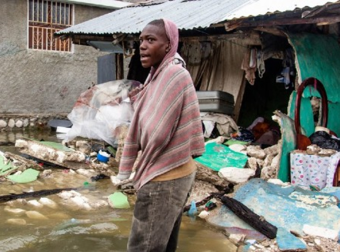 A young man stands outside a row of buildings destroyed by a 7.2 magnitude earthquake in Haiti followed by a storm surge from Tropical Depression Grace. (UNICEF photo)