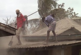Men clean volcanic ash from the roof of a house in Owia last Week Wednesday, April 21, 2021. (iWN/CMC photo)