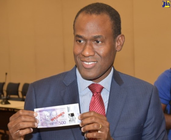Finance and Public Service Minister, Dr. Nigel Clarke showing off one fo the new notes (JIS Photo)