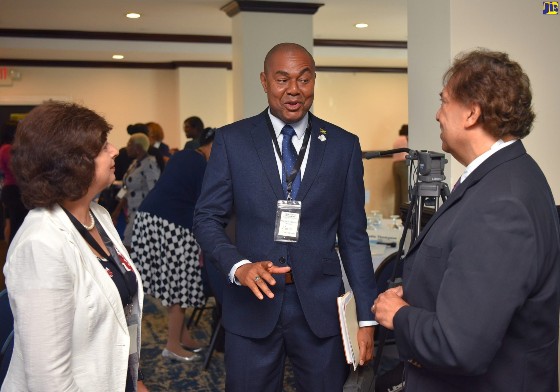 Executive Director, Financial Services Commission (FSC), Major Keron Burrell (centre), converses with (from left) Senior Programmes Director, Toronto Centre, Shelina Visram and Senior Partner, TELUS Health, Al Kiel. Occasion was the opening ceremony for the Caribbean Association of Pensions Supervisors (CAPS) Conference at The Jamaica Pegasus hotel in New Kingston on Tuesday (June 13). (Photo courtesy of YHOMO HUTCHINSON/JIS)