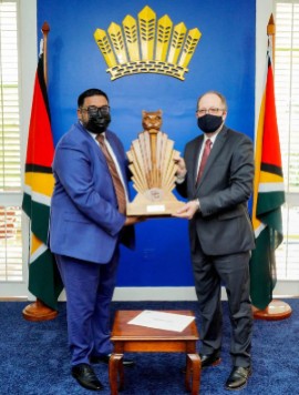President Dr. Irfaan Ali (Left) presenting gift to outgoing CARICOM Secretary General, Irwin LaRocque (OP Photo)