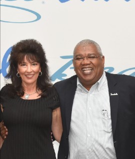 Pictured with her is  Gary Sadler, Executive Vice President of Sales & Industry Relations at Unique Vacations, Inc.