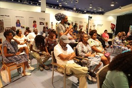 An audience member asks a question of the panelists at a hybrid Island SPACE presentation. Over his shoulder, the camera allows viewers online to watch and engage in real time as well. | Photo by David I. Muir (Island Syndicate)