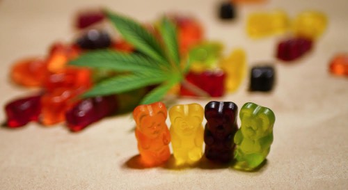 Cannabis infused gummy bears. Medical CBD candies. Mixed colors. Marijuana leaf. Alternative medicine. Anxiety therapy.