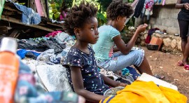 Family sits in the rubble of the house they lost in a 7.2 magnitude earthquake in Haiti. (UNICEF Photo)