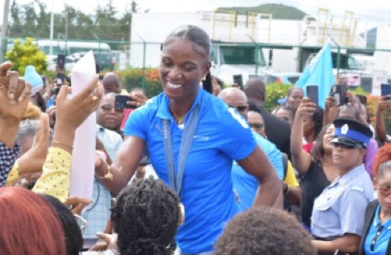 Julien Alfred interacts with supporters after arriving home in St Lucia.