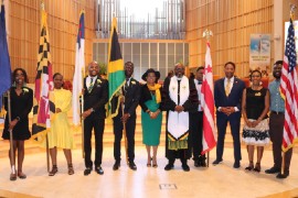 Jamaica’s Ambassador to the United States, Her Excellency Audrey Marks and Minister of webster Memorial United Church Rev. Astor Caryle (center) are flank by flag bears at last year service of thanksgiving at the Sligo Seventh Day Adventist Church Takoma Park Maryland. (Photo by Derrick Scott)