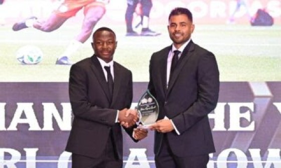 Omari Glasgow (left) receives his Sportsman of the Year award from Minister of Culture, Youth and Sport, Charles Ramson Jr.