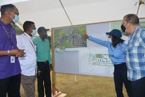 Minister of Transport and Mining, Hon. Audley Shaw (right), and State Minister, Hon. J.C. Hutchinson (center), are briefed by Jamaica Bauxite Mining Limited’s (JBM) Managing Director, Donna Marie Howe (second right), on the multi-million dollar commercial and industrial park development project. (Photo courtesy of Okoye Henry/JIS)