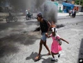 A school child being guided by her parent in the violent plague Port au Prince (File Photo)