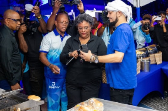 Prime Minister Mia Mottley makes the first BiMPay transaction with a local vendor. Among those witnessing the transaction was the Governor of the Central Bank of Barbados, Dr Kevin Greenidge. (Photo credit: Central Bank of Barbados)