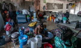 A displaced woman washes clothes at a disused theatre. in downtown Port of Spain (UN Photo)