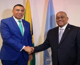 Prime Minister Andrew Holness (left) and Haiti’s Prime Minister Garry Conille greet each other at the start of their talks.