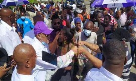 Former president, Desi Bouterse , in blue cap, is surrounded by supporters after leaving the Court on the first day of his appeal.