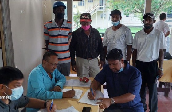 GAWU President Seepaul Narine (left) and GuySuCo CEO Sasenarine Singh (right) signing of the agreement reached on Sunday
