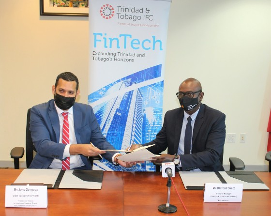 John Outridge, Chief Executive Officer of TTIFC, and Dalton Fowles, Mastercard Country Manager for Jamaica and Trinidad & Tobago, sign the MOU.