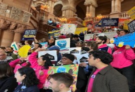 People join lawmakers and immigration advocates in calling for funding to help migrants in New York