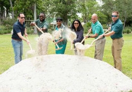 At left, Chairwoman Edmonson, along with County Parks Recreation and Open Spaces Department Director Maria Nardi (third from right) and Parks staff, breaks ground on a new community recreation center at Biscayne Shores and Gardens Park.  (Photos by Godfrey Mead / Miami-Dade County)