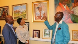 Jamaican artist Paul Blackwood, right, explains his work to Jamaica’s Ambassador to the United States Audrey Marks, center, and fellow artist Courtney Morgan
