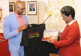Lisa Bryant Smart, right, Jamaica’s acting consul general in New York, receives memen-tos depicting Falmouth, Jamaica from Lance Hall, director of Friends of Falmouth, after she officially launched the organization at the Jamaica Consulate in Manhattan, New York last month. The newly formed organization is aiming to encourage former residents of Falmouth to pool their resources and talents towards the improvement of their home-town. Photograph by Derrick Scott