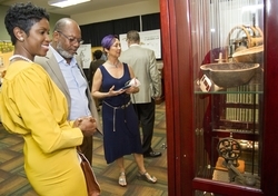 Nadia Assad, left, constituent service representative, City of North Miami, is joined by City of Lauderhill Mayor Ken Thurston, center, and retired Lauderhill police officer Debbie Banner in observing some of the artifacts at the exhibition.