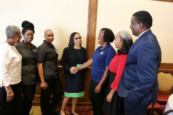 Labour and Social Security Minister Shahine Robinson (centre) greets Patricia Patterson-Brown, who has been in the Ministry’s hotel work for 17 years. Looking on from left to right: JCLO Chief Laison Officer Methelina Scarlett-Jones; Evette McLeod; Keshien Blair; Permanent Secretary in the Ministry of Labour, Mrs. Collette Roberts Risden; and JCLO Liaison Officer for Michigan Gladstone Moore. Photo Credit: Derrick Scott