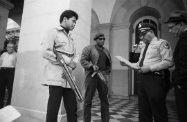 Two members of the Black Panther Party are met by Police Lt. Ernest Holloway on the steps of the State Capitol in Sacramento, CA on May 2, 1967. Photo: Bettmann/Getty Images