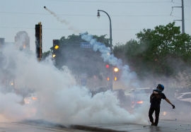 A protester throws a gas canister back at police during a protest over the killing of George Floyd in Minneapolis on May 26, 2020. (Chris Juhn/Zenger)