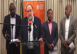 Opposition and JLP leader, Mark Golding, flanked by PNP members, speaking at news conference on Tuesday (CMC Photo)