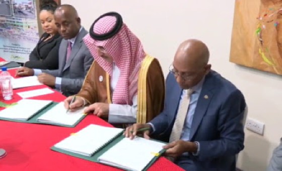 Dominica’s Prime Minister Roosevelt Skerrit looks on as his Finance Minister Dr. Irving McIntyre and SFD chief executive officer, Sultan Al-Marshad, signing the loan agreement.