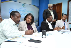 Minister with Responsibility for Land Titling and Settlements in the Ministry of Economic Growth and Infrastructure Development, Robert Montague (left), signs contracts for the construction of semi-permanent housing solutions for Hurricane Melissa-affected families in Westmoreland and St. Elizabeth. (Photo credit: JIS)