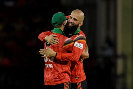 Moeen Ali (right) celebrates with Imran Tahir after capturing one of his three wickets against the Antigua & Barbuda Falcons.