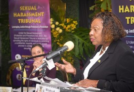 Minister of Culture, Gender, Entertainment and Sport Olivia Grange addressing the swearing-in ceremony for the Sexual Harassment Tribunal. Looking on is Minister of Foreign Affairs Senator Kamina Johnson Smith.