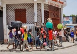 People who have fled their homes carry their belongings in Port-au-Prince, Haiti (PAHO Photo)