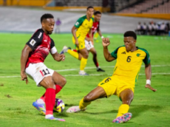 T&T’s Levi Garcia (l) gets by Reggae Boyz defender Richard King during their Concacaf World Cup Qualifier at the National Stadium in Kingston on Tuesday. Photo: Concacaf