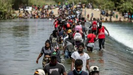 Migrants cross the Rio Grande near a temporary migrant camp under the international bridge in Del Rio, Texas © Jordan Vonderhaar/Getty Images