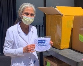 Sharon Burbelo, Maternal Family Health Liaison at The Women’s Hospital at Jackson Memorial, holds a “Future M-DCPS Grad” bib that is included in the care package for parents of newborns delivered at Jackson Health System hospitals.