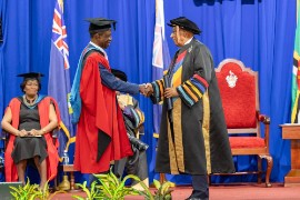 Honorary Graduate Ralph Taylor exchanges a handshake with Chancellor of The UWI, Dr. Dodridge Miller.