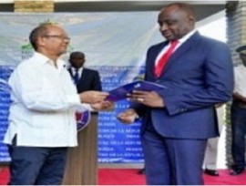 Head of the Presidential Transitional Council, Leslie Voltaire (left) hands over the official documents to newly installed Secretary of State for Public Security, Mario Andrésol.