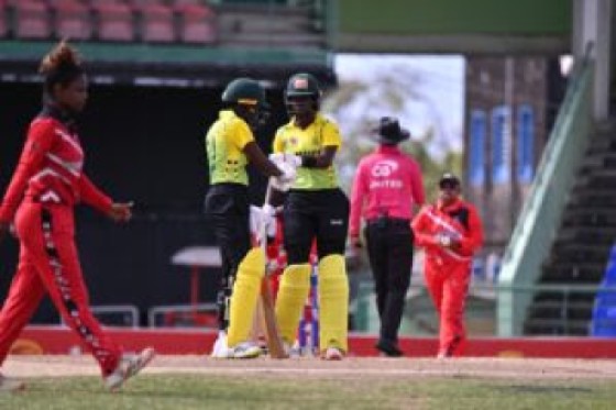 Jamaica Women captain Rashada Williams (3rd left) and fellow opener Chrishana McKenzie meet mid pitch during their match against Trinidad & Tobago Women in the CG United Women’s Super 50 Cup at Warner Park on Monday. Photo: CWI Media